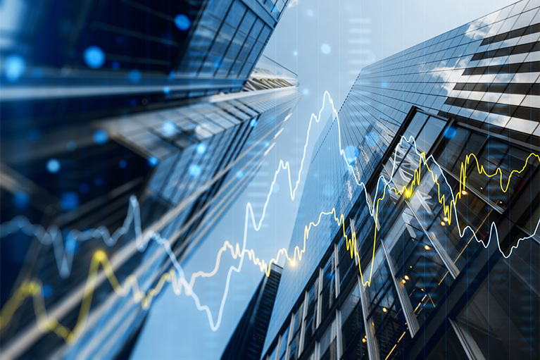 Photo of a chart with yellow and blue lines, representing portfolio growth, overlaid on an image of buildings.