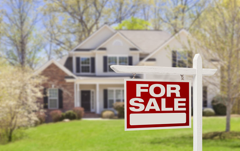 A large house with a for sale sign in the front garden