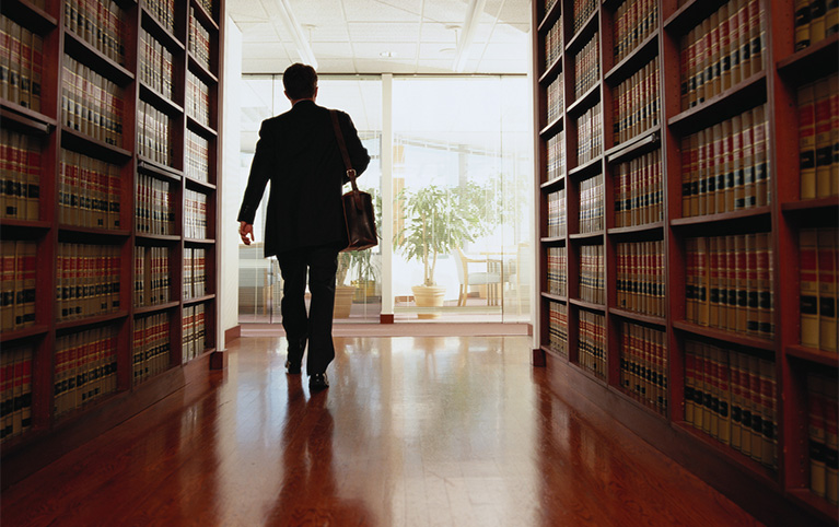 An image of a professional walking in the library.