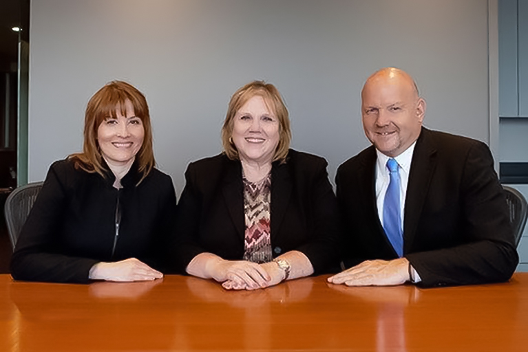 3 persons in front of a table.