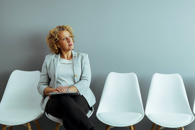 A woman sitting reflecting on whether her financial situation will be ok. 