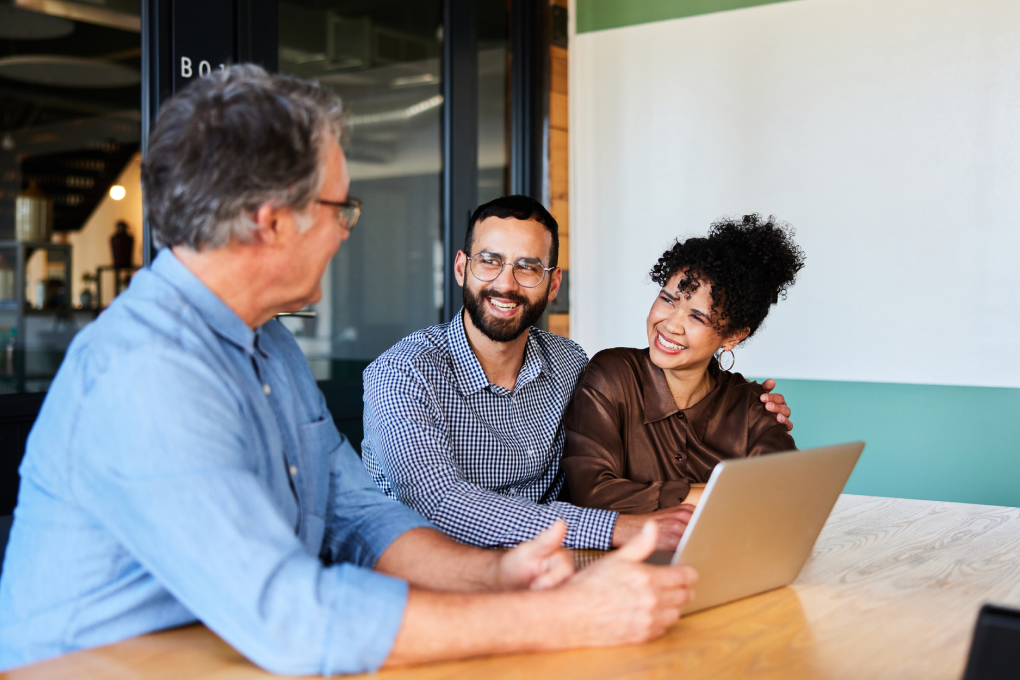 Photo of a young couple meeting with their investment advisor